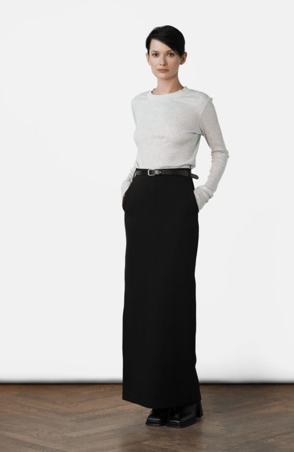 A woman in white shirt and black skirt